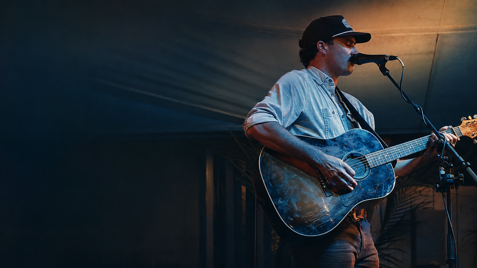 Pierce August performing live with an acoustic guitar