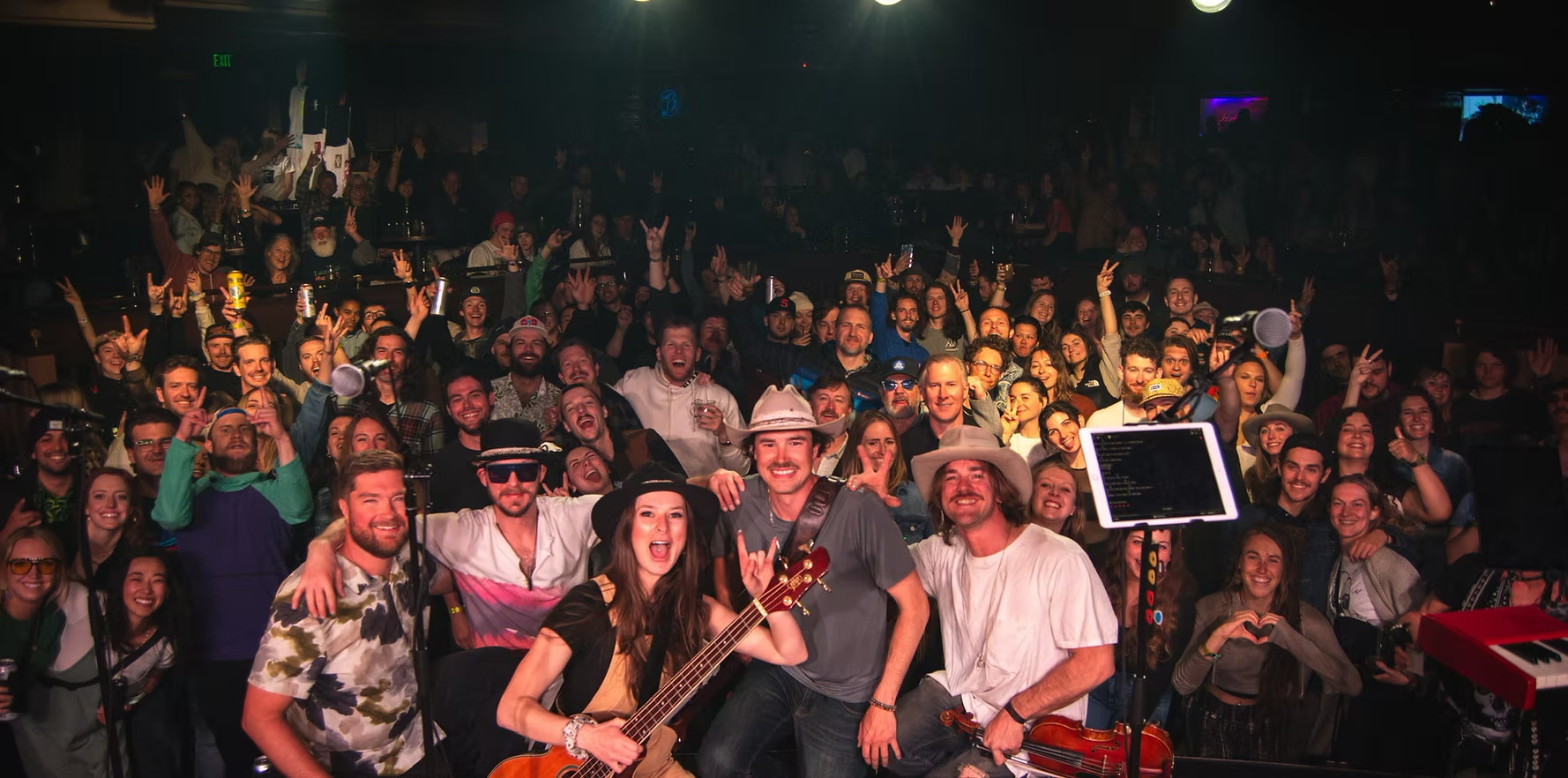 Pierce August and his band on stage with a packed, cheering crowd